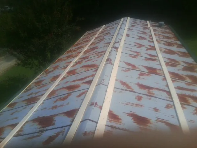 Rusted metal roof panels with new wood purlins before replacement — Storm Damage Roof Repair in Elwell by Roofing Brothers